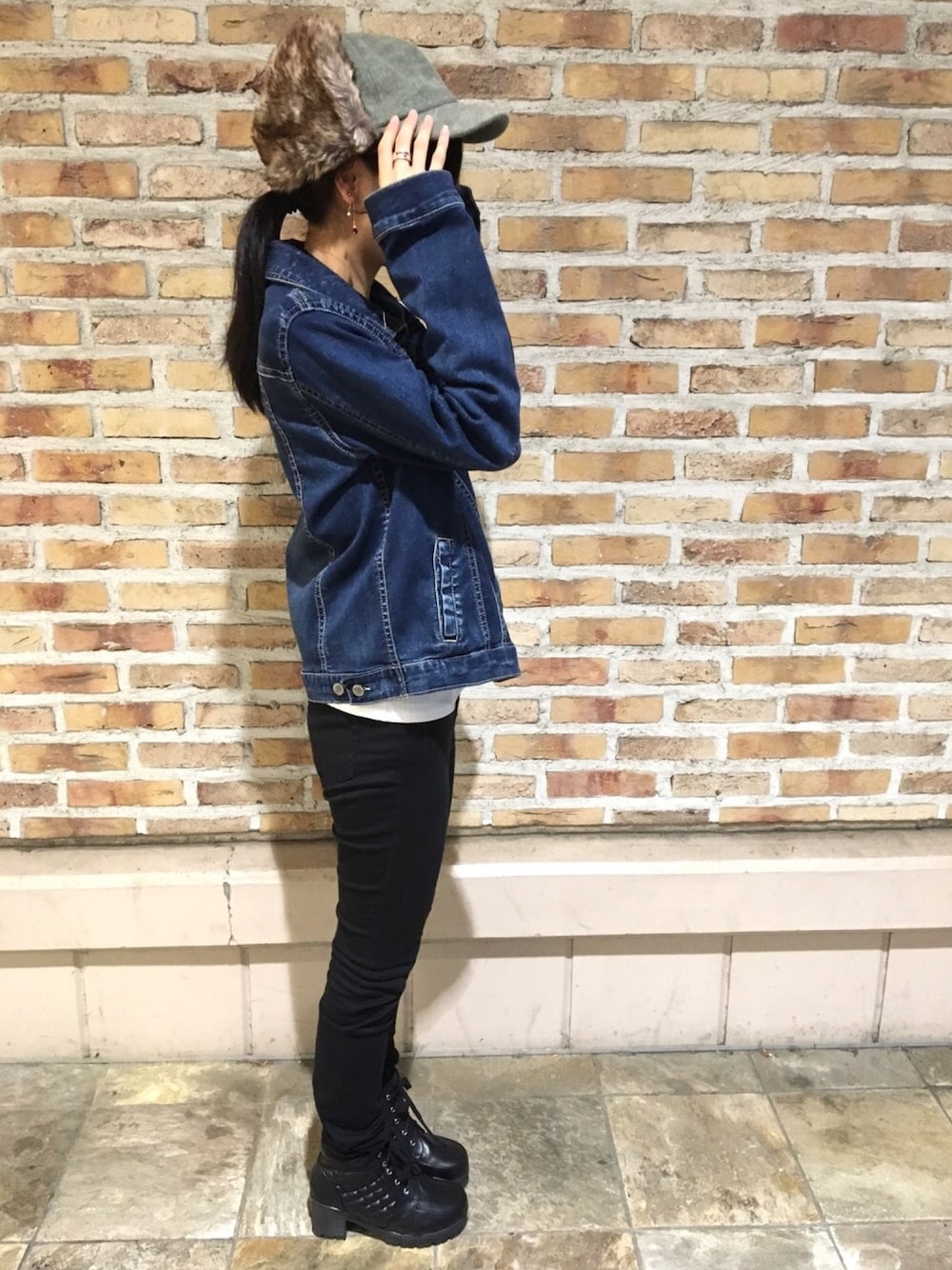 ホワイト系のニット/セーター、ブラック系のデニムパンツ、ブラウン系のキャップを着用したメンズの秋コーディネートの1枚目の写真