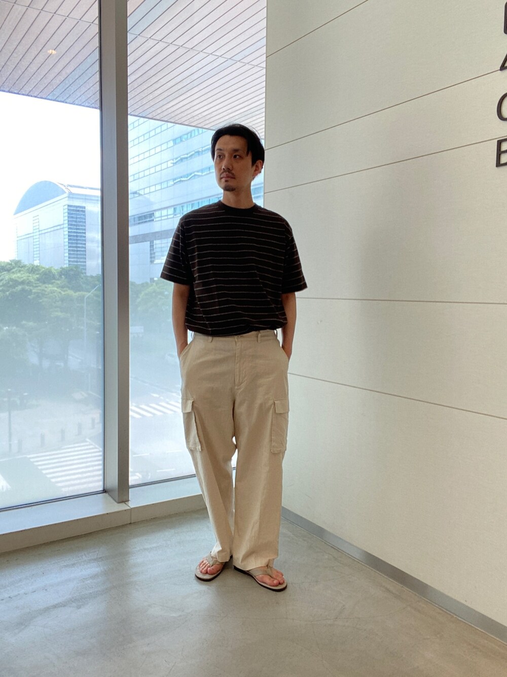 ブラウン系のTシャツ/カットソー、ホワイト系のパンツ、ベージュ系のサンダルを着用したメンズの夏コーディネートの1枚目の写真