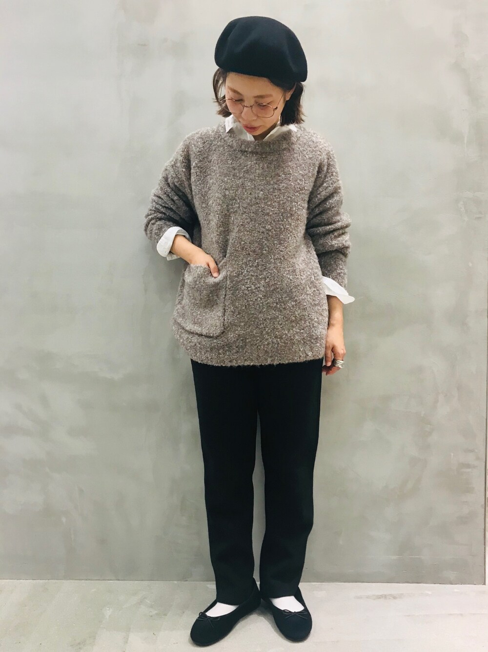 ブラウン系のニット/セーター、ブラック系のスラックス、ホワイト系のシャツ/ブラウスを着用したレディースの秋コーディネートの1枚目の写真