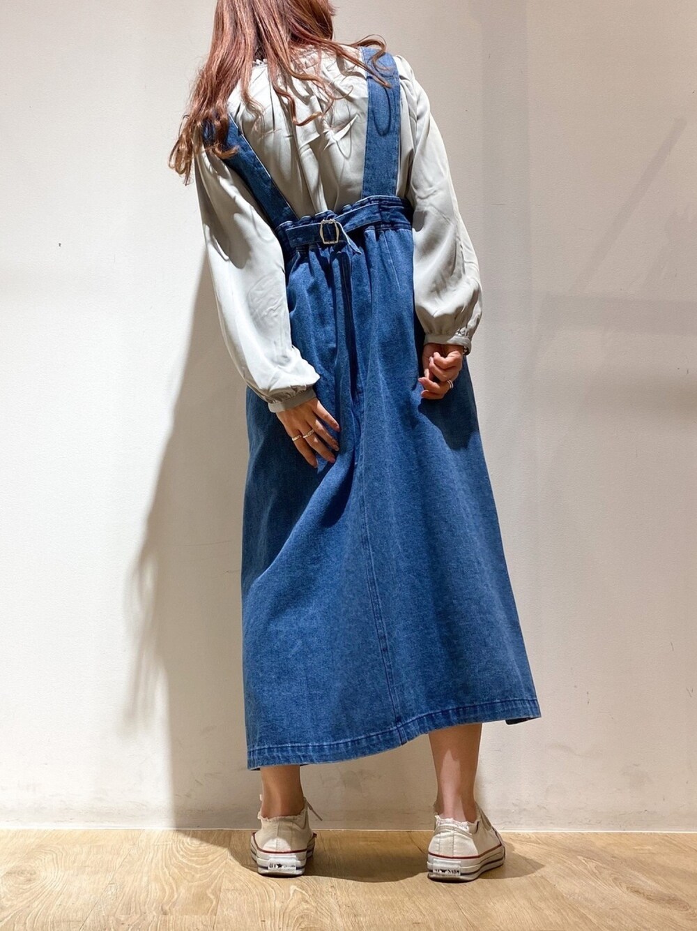 ブラック系のジャンパースカート、ブルー系のシャツ/ブラウスを着用したレディースの春コーディネートの1枚目の写真