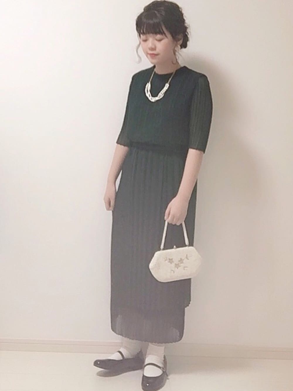 ブラック系のバレエシューズ、ホワイト系のバッグ、グリーン系のワンピース/ドレスを着用したレディースの冬コーディネートの1枚目の写真