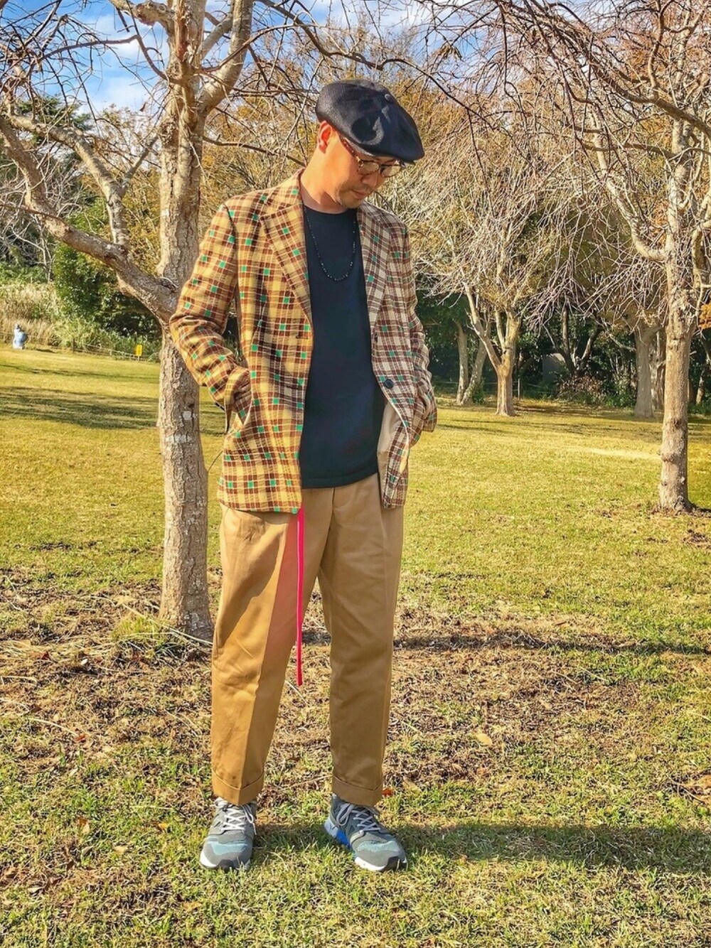 ブラック系のTシャツ/カットソー、ブラウン系のテーラードジャケット、ベージュ系のチノパンツを着用したメンズの秋コーディネートの1枚目の写真