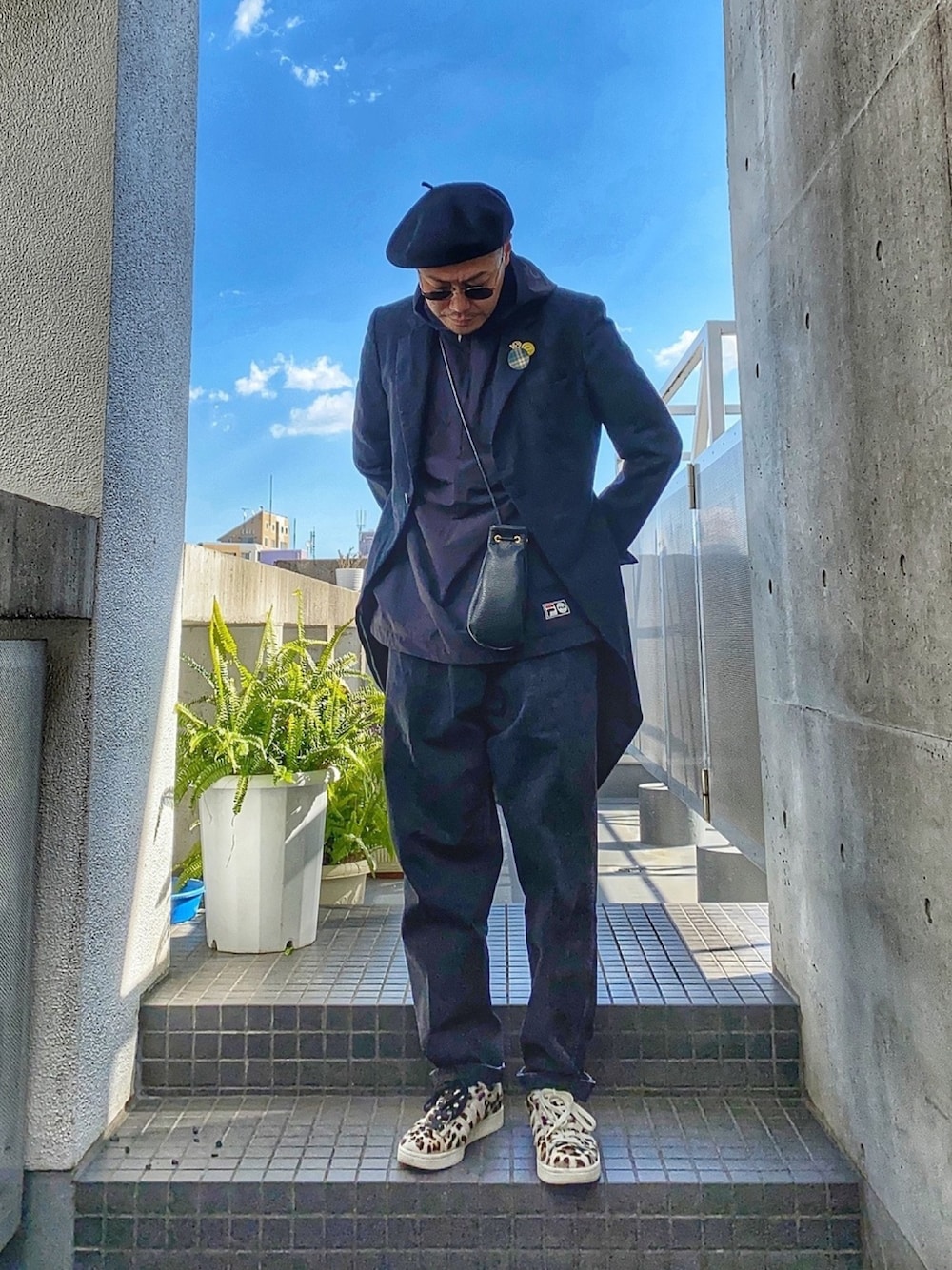 ブラック系のショルダーバッグ、グレー系のスーツジャケット、ブラック系のパーカーを着用したメンズの冬コーディネートの1枚目の写真