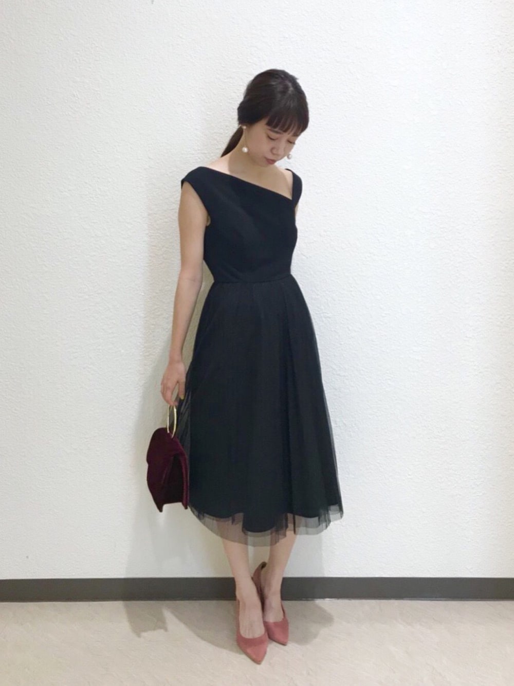 ブラック系のドレス、ピンク系のパンプス、レッド系のバッグを着用したレディースの夏コーディネートの1枚目の写真