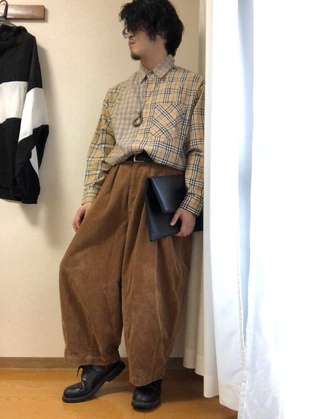 ブラウン系のパンツ、ベージュ系のシャツ/ブラウス、ブラック系のクラッチバッグを着用したメンズの秋コーディネートの1枚目の写真