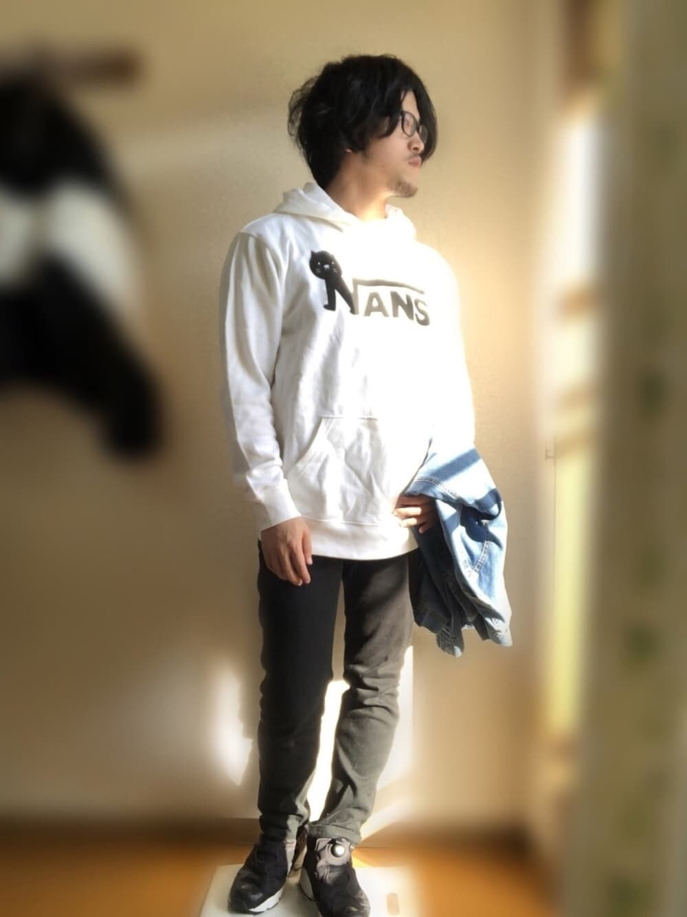 ホワイト系のパーカー、ブルー系のデニムジャケット、ブラック系のパンツを着用したメンズの秋コーディネートの1枚目の写真