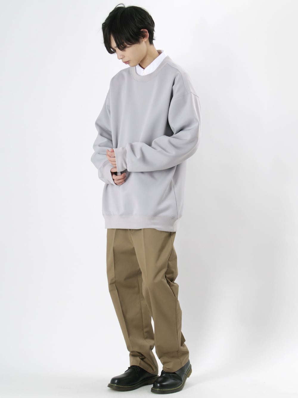 グレー系のスウェット、ホワイト系のシャツ/ブラウス、ベージュ系のチノパンツを着用したメンズの春コーディネートの1枚目の写真