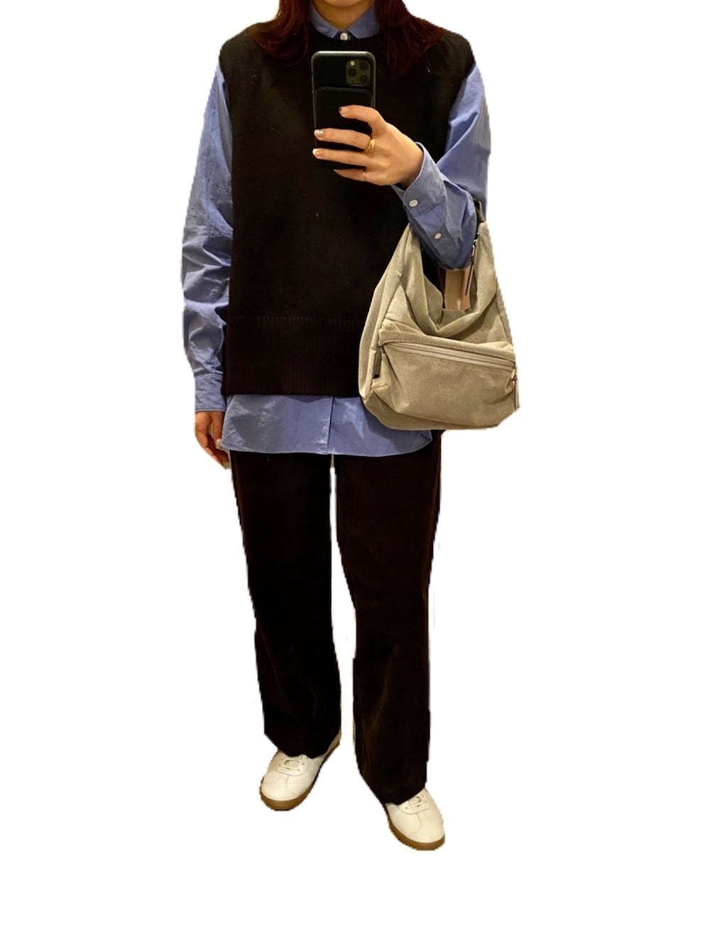 ブラック系のベスト、ホワイト系のスニーカー、グレー系のショルダーバッグを着用したレディースの秋コーディネートの1枚目の写真