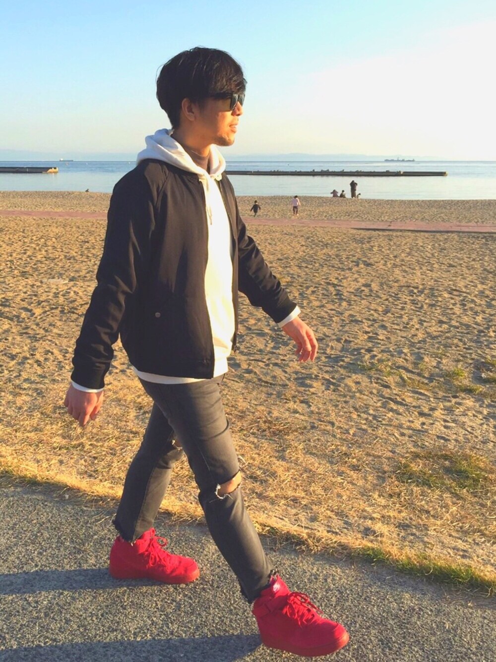 ホワイト系のパーカー、ブラック系のブルゾン、ブラック系のデニムパンツを着用したメンズの冬コーディネートの1枚目の写真