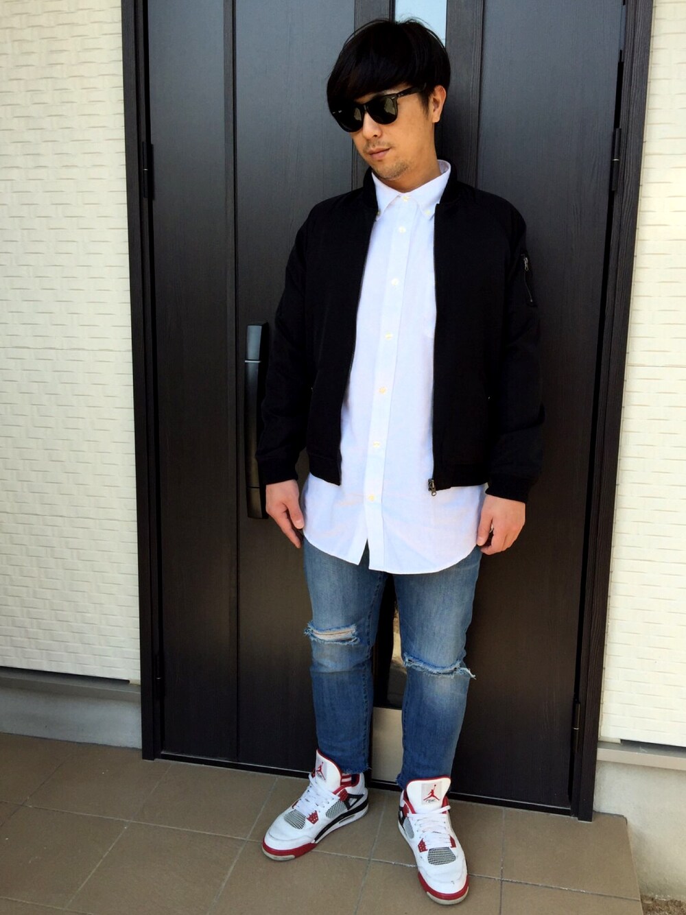 ブラック系のブルゾン、ホワイト系のシャツ/ブラウス、ブルー系のデニムパンツを着用したメンズの冬コーディネートの1枚目の写真