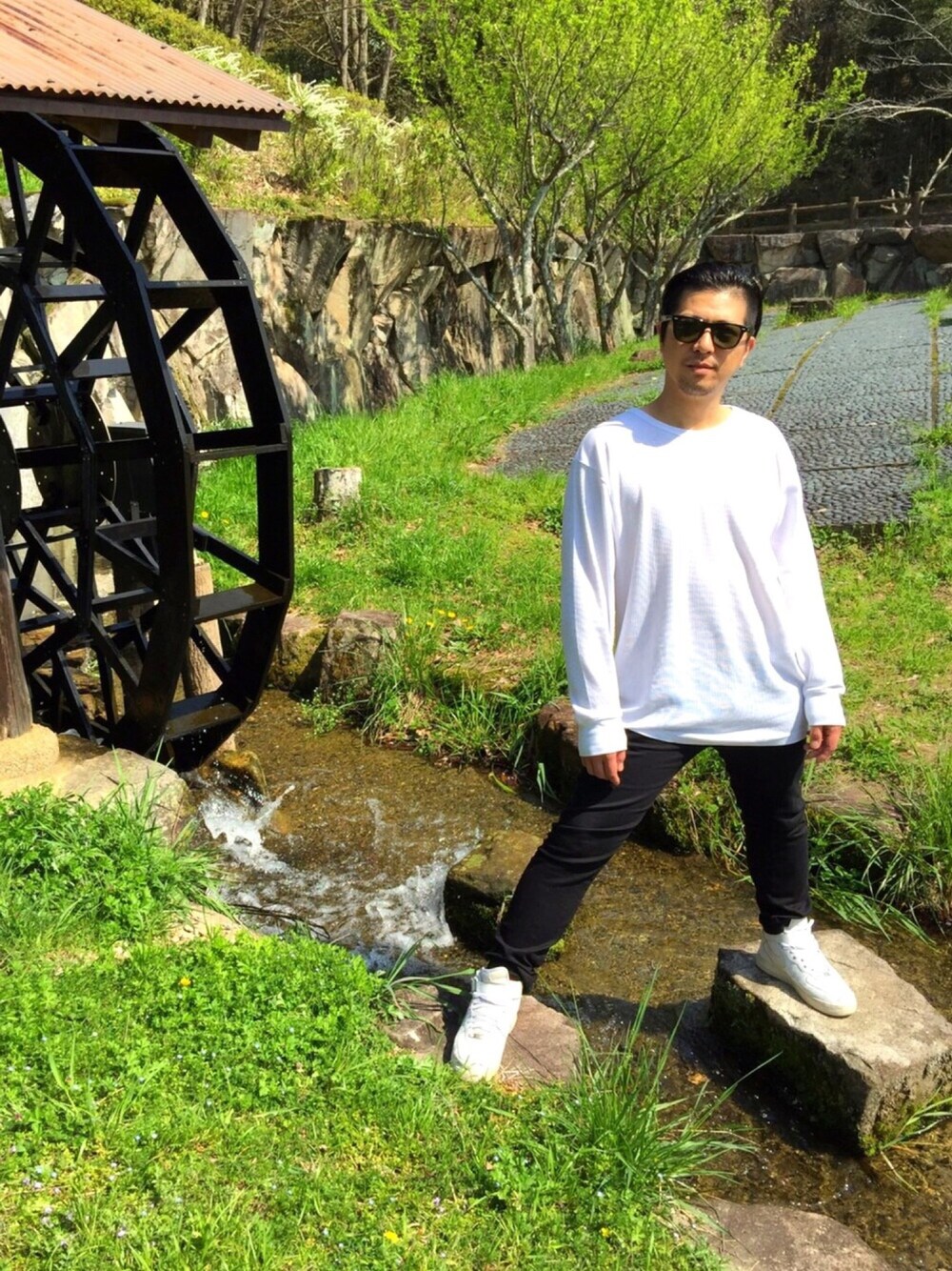 ホワイト系のTシャツ/カットソー、ブラック系のデニムパンツ、ホワイト系のスニーカーを着用したメンズの春コーディネートの1枚目の写真