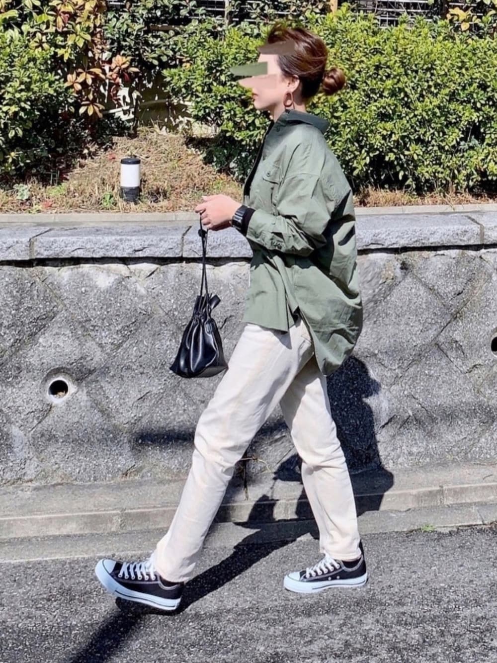 グリーン系のシャツ/ブラウス、ベージュ系のデニムパンツ、ブラック系のショルダーバッグを着用したレディースの春コーディネートの1枚目の写真