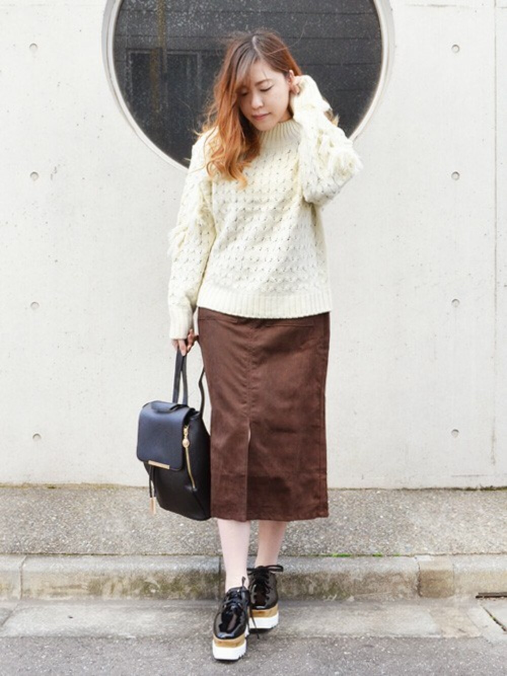 ブラック系のローファー、ベージュ系のスカート、ホワイト系のニット/セーターを着用したレディースの秋コーディネートの1枚目の写真