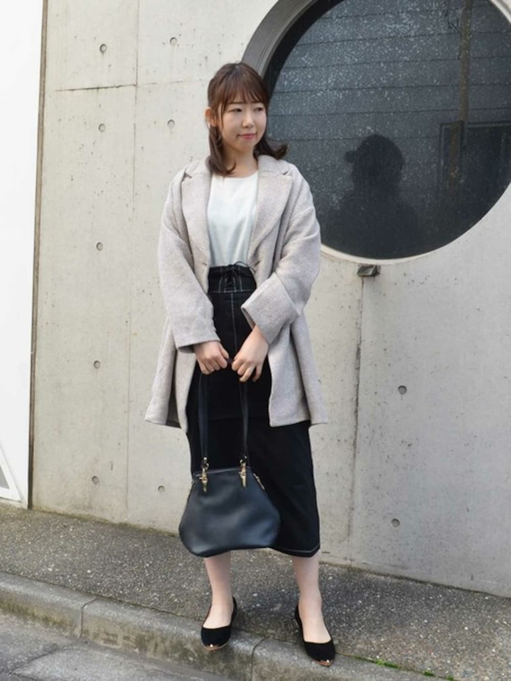 ベージュ系のチェスターコート、ホワイト系のTシャツ/カットソー、ブラック系のパンプスを着用したレディースの冬コーディネートの1枚目の写真