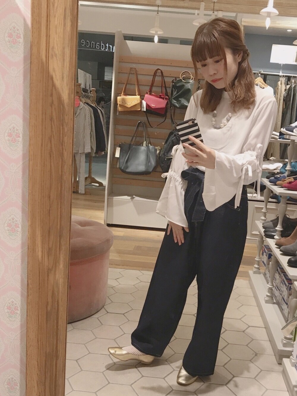 ホワイト系のシャツ/ブラウス、ブルー系のパンツを着用したレディースの秋コーディネートの1枚目の写真