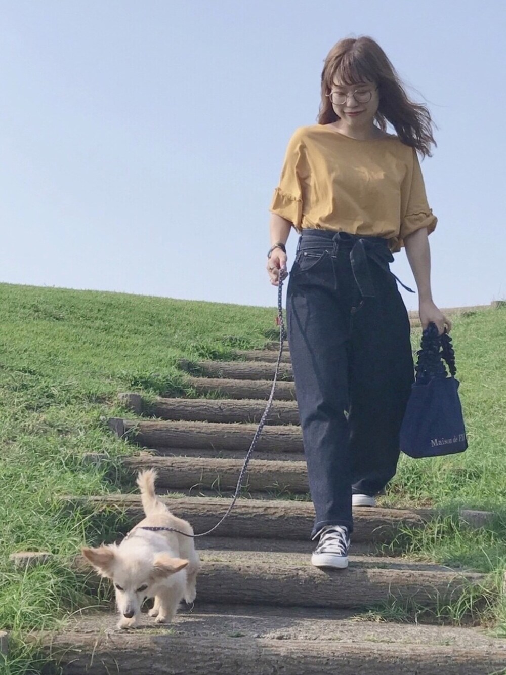 イエロー系のTシャツ/カットソー、ブルー系のトートバッグ、ブルー系のパンツを着用したレディースの秋コーディネートの1枚目の写真