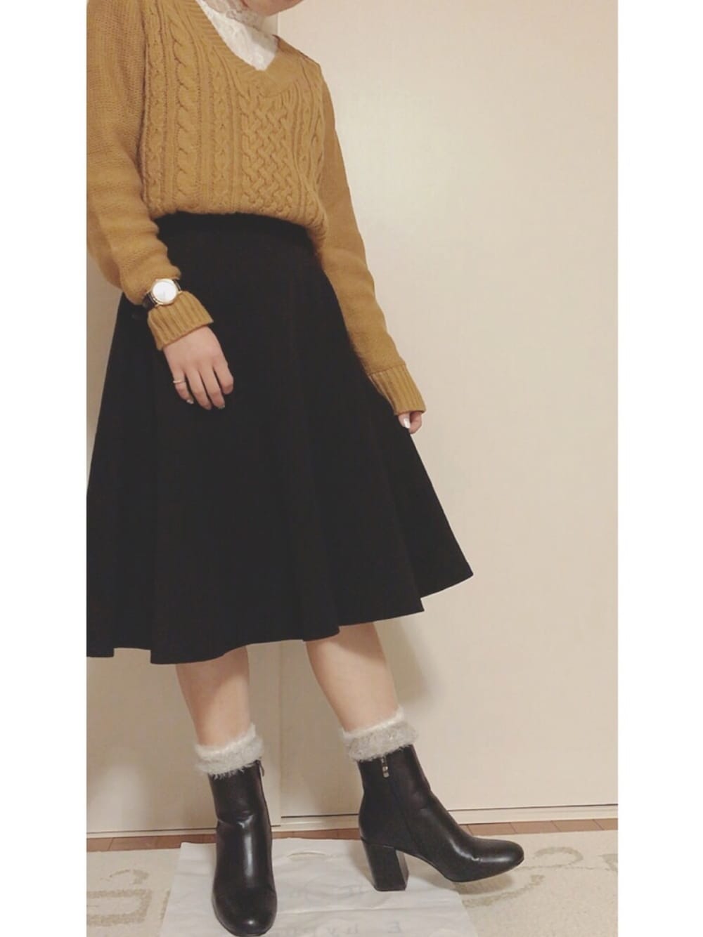 ホワイト系のワンピース、イエロー系のニット/セーターを着用したレディースの冬コーディネートの1枚目の写真