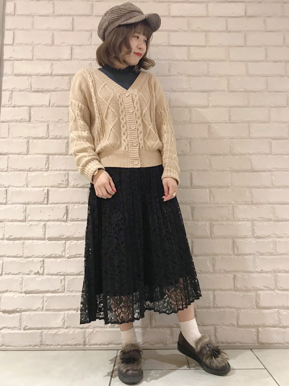 グリーン系のニット/セーター、ベージュ系のニット/セーター、ブラック系のスカートを着用したレディースの冬コーディネートの1枚目の写真