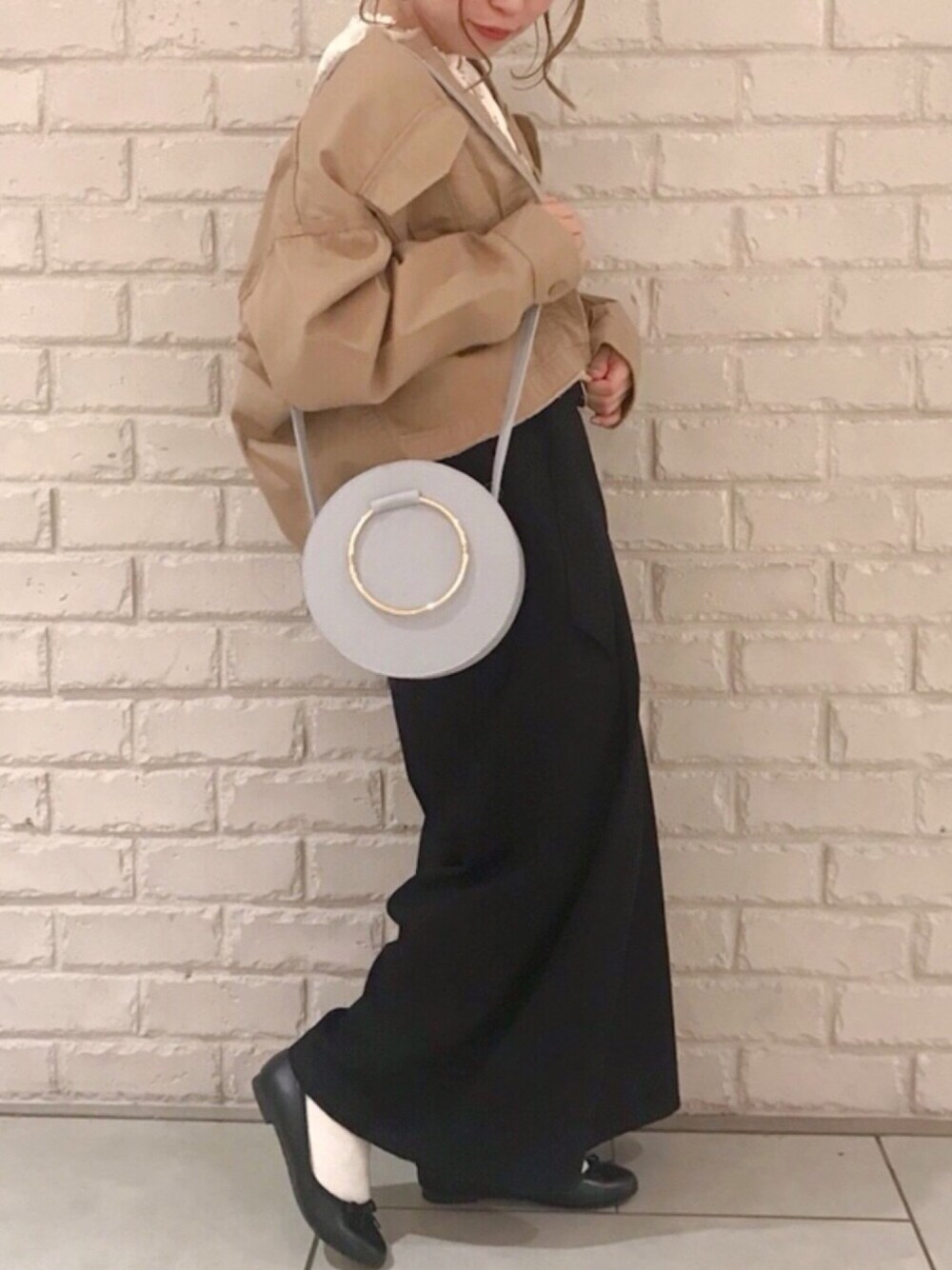 ベージュ系のブルゾン、ブルー系のショルダーバッグ、ブラック系のその他パンツを着用したレディースの春コーディネートの1枚目の写真