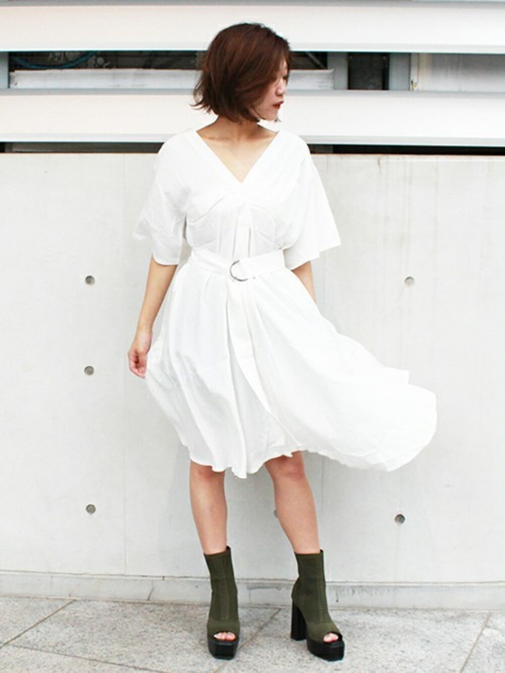 ホワイト系のシャツワンピース、グリーン系のブーティを着用したレディースの夏コーディネートの1枚目の写真