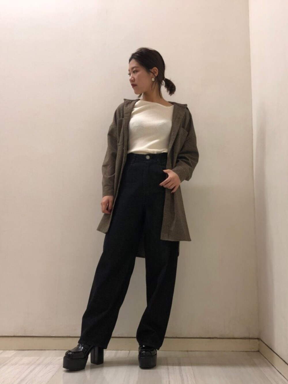 イエロー系のシャツ/ブラウス、ホワイト系のニット/セーター、ブラック系のデニムパンツを着用したレディースの秋コーディネートの1枚目の写真