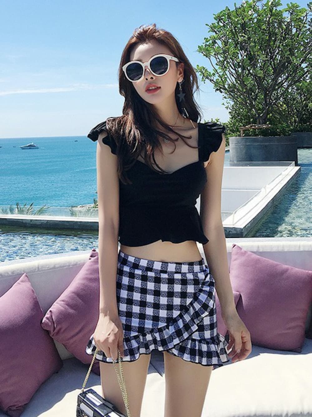 ブラック系の水着を着用したレディースの夏コーディネートの1枚目の写真