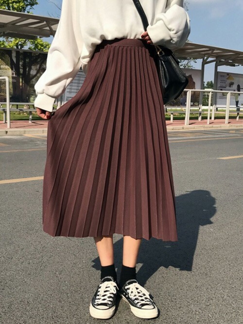 レッド系のスカートを着用したレディースの秋コーディネートの1枚目の写真