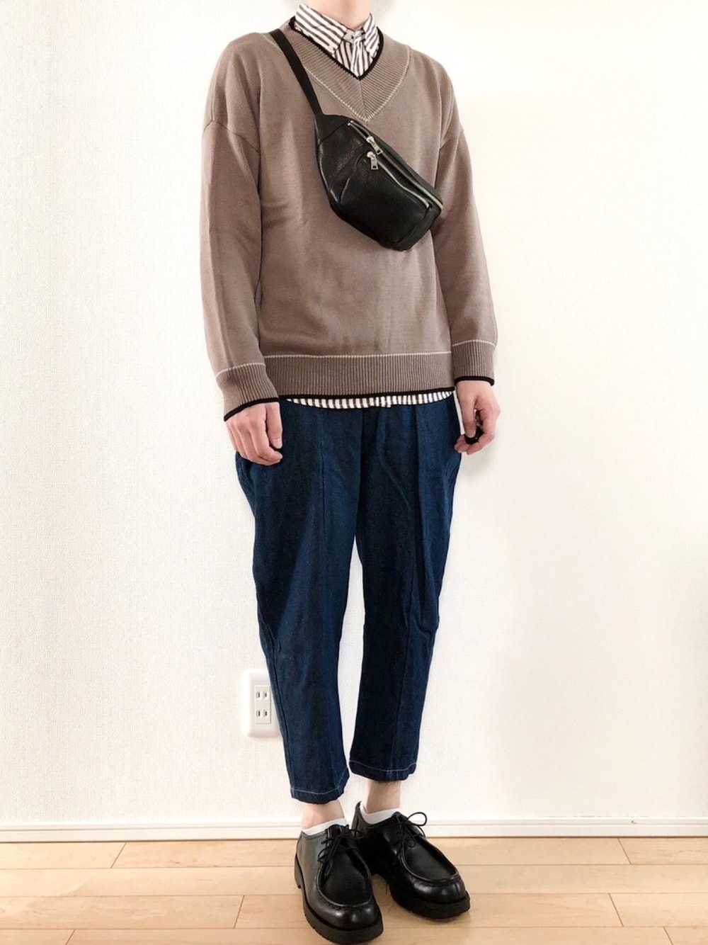 ベージュ系のニット/セーター、ブラウン系のシャツ/ブラウス、ブルー系のデニムパンツを着用したメンズの秋コーディネートの1枚目の写真