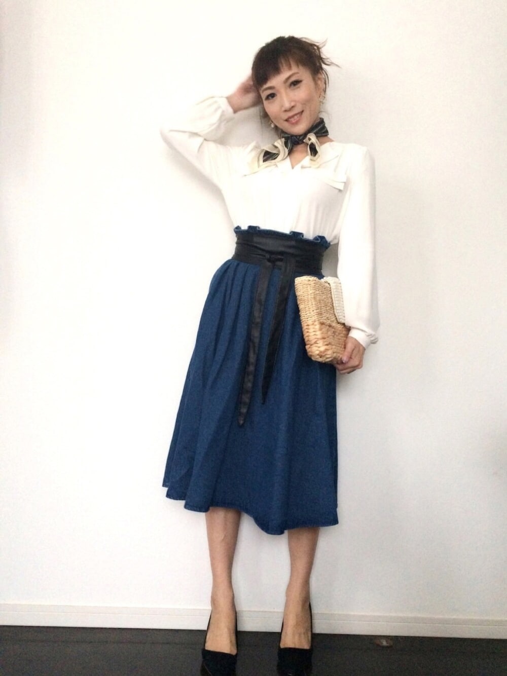 ホワイト系のシャツ/ブラウス、ベージュ系のクラッチバッグ、ブルー系のデニムスカートを着用したレディースの春コーディネートの1枚目の写真