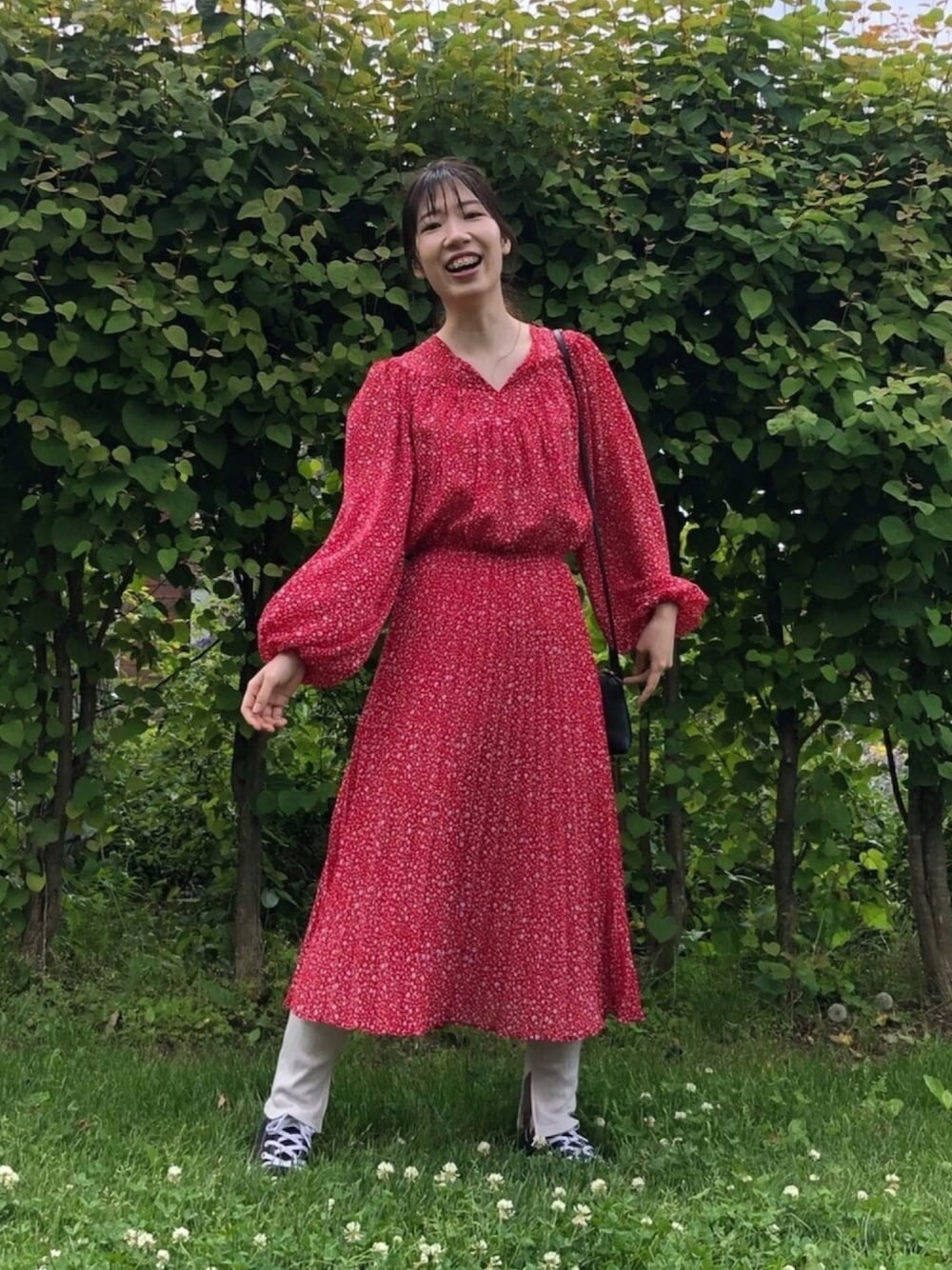 レッド系のワンピース/ドレス、ブラック系のショルダーバッグ、ブラック系のスニーカーを着用したレディースの夏コーディネートの1枚目の写真