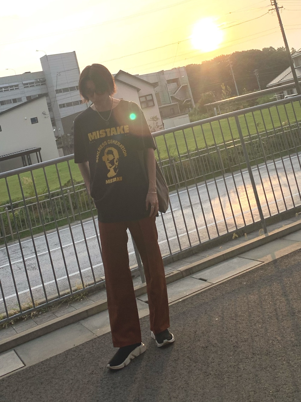 ブラック系のTシャツ/カットソー、レッド系のパンツ、ブラック系のスニーカーを着用したメンズの秋コーディネートの1枚目の写真