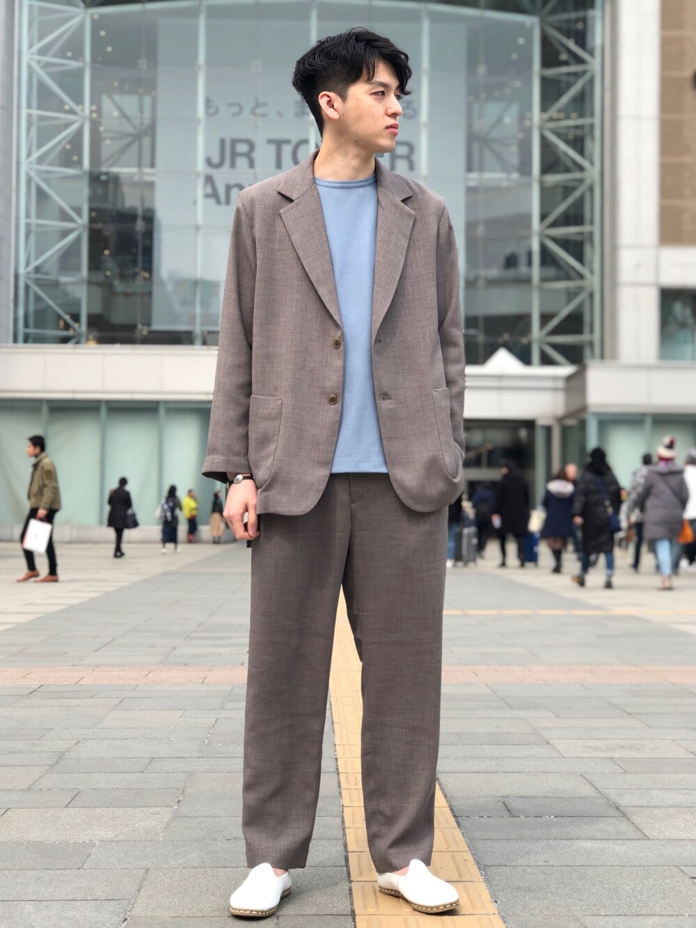 グリーン系のテーラードジャケット、グリーン系のスラックス、ブルー系のTシャツ/カットソーを着用したメンズの春コーディネートの1枚目の写真
