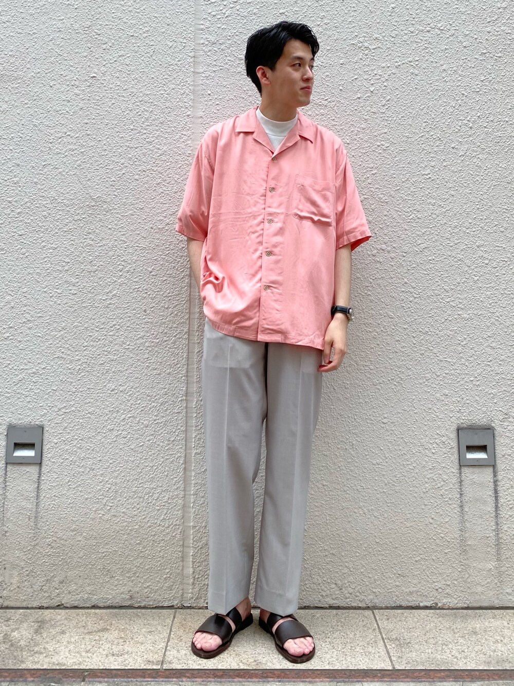 ピンク系のシャツ/ブラウス、グレー系のスラックス、ブラウン系のサンダルを着用したメンズの春コーディネートの1枚目の写真