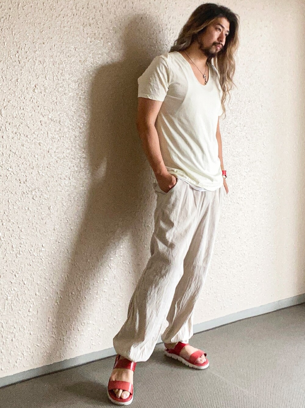 レッド系のサンダル、ベージュ系のその他パンツ、イエロー系のTシャツ/カットソーを着用したメンズの夏コーディネートの1枚目の写真