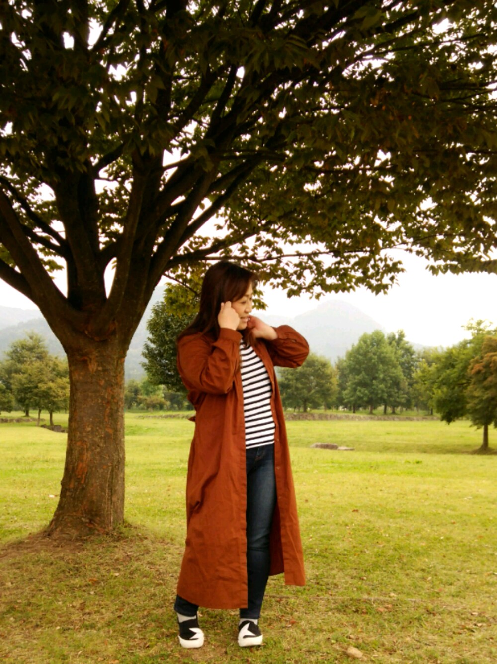 ブルー系のデニムパンツ、ホワイト系のTシャツ/カットソー、ブラウン系のノーカラージャケットを着用したレディースの秋コーディネートの1枚目の写真