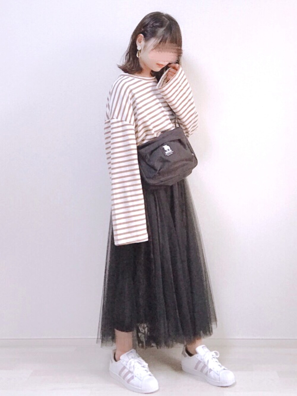 ブラウン系のTシャツ/カットソー、ブラック系のショルダーバッグ、ブラック系のスカートを着用したレディースの春コーディネートの1枚目の写真