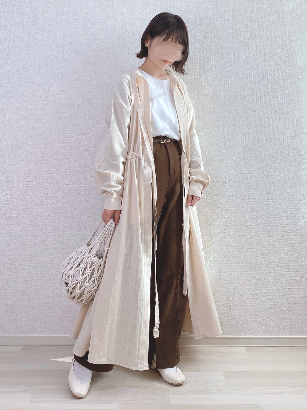 ベージュ系のシャツワンピース、ブラウン系のその他パンツ、ホワイト系のTシャツ/カットソーを着用したレディースの春コーディネートの1枚目の写真