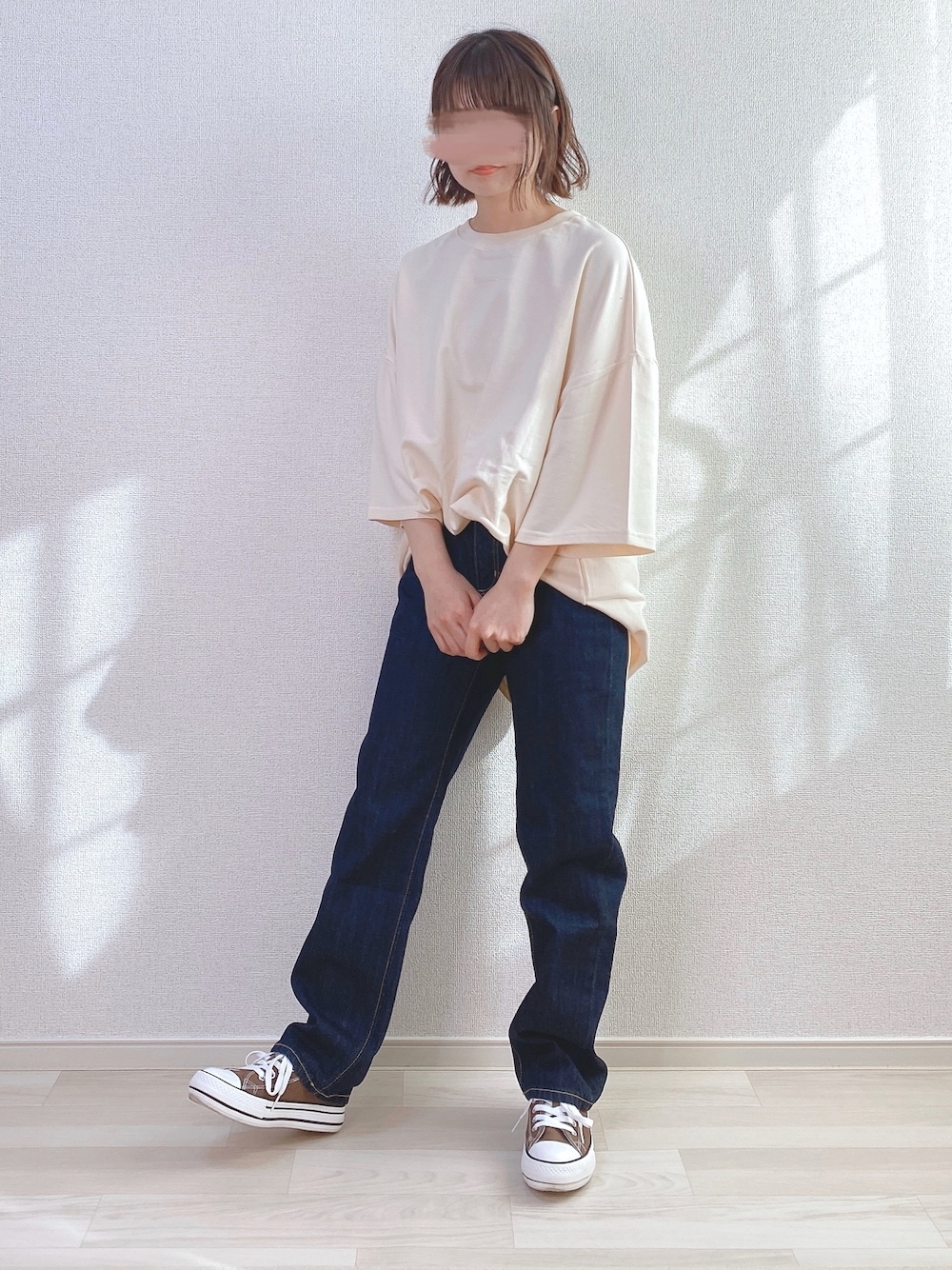 ベージュ系のTシャツ/カットソー、ブルー系のデニムパンツ、ブラウン系のスニーカーを着用したレディースの春コーディネートの1枚目の写真