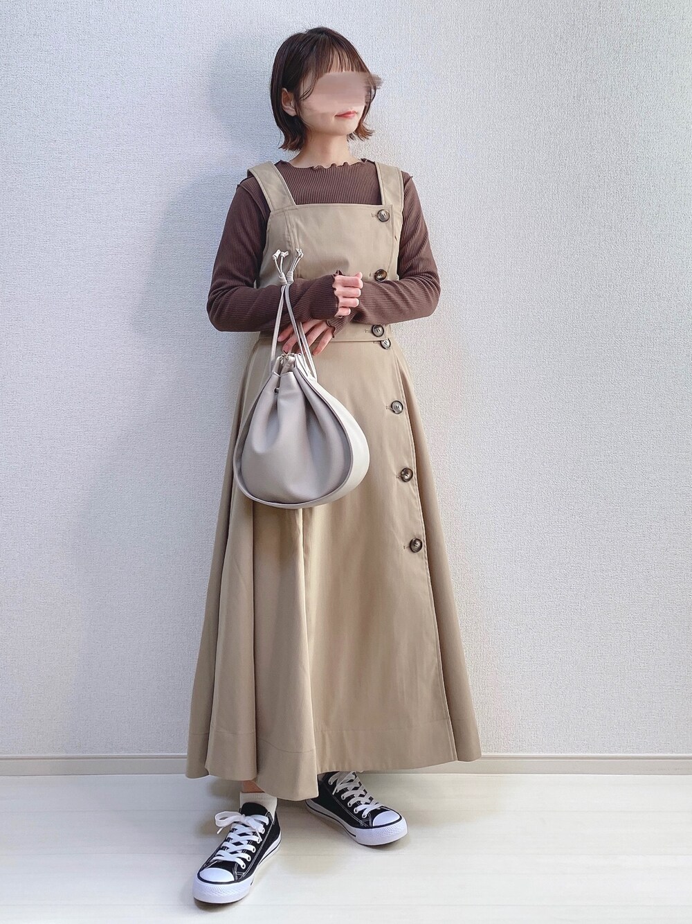 ベージュ系のトレンチコート、ベージュ系のショルダーバッグ、ブラック系のスニーカーを着用したレディースの春コーディネートの1枚目の写真