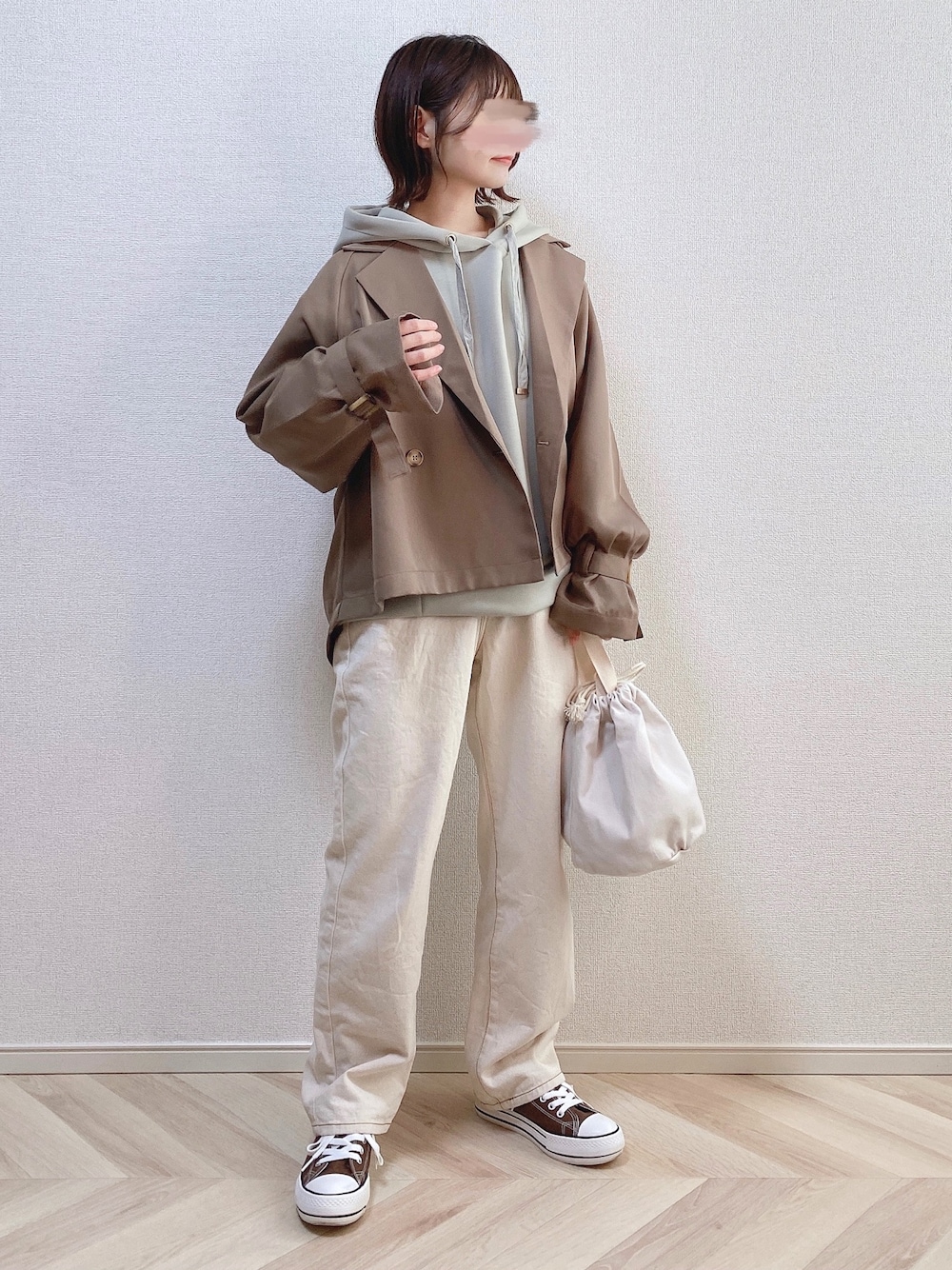 ブラウン系のトレンチコート、グリーン系のパーカー、ホワイト系のその他パンツを着用したレディースの春コーディネートの1枚目の写真