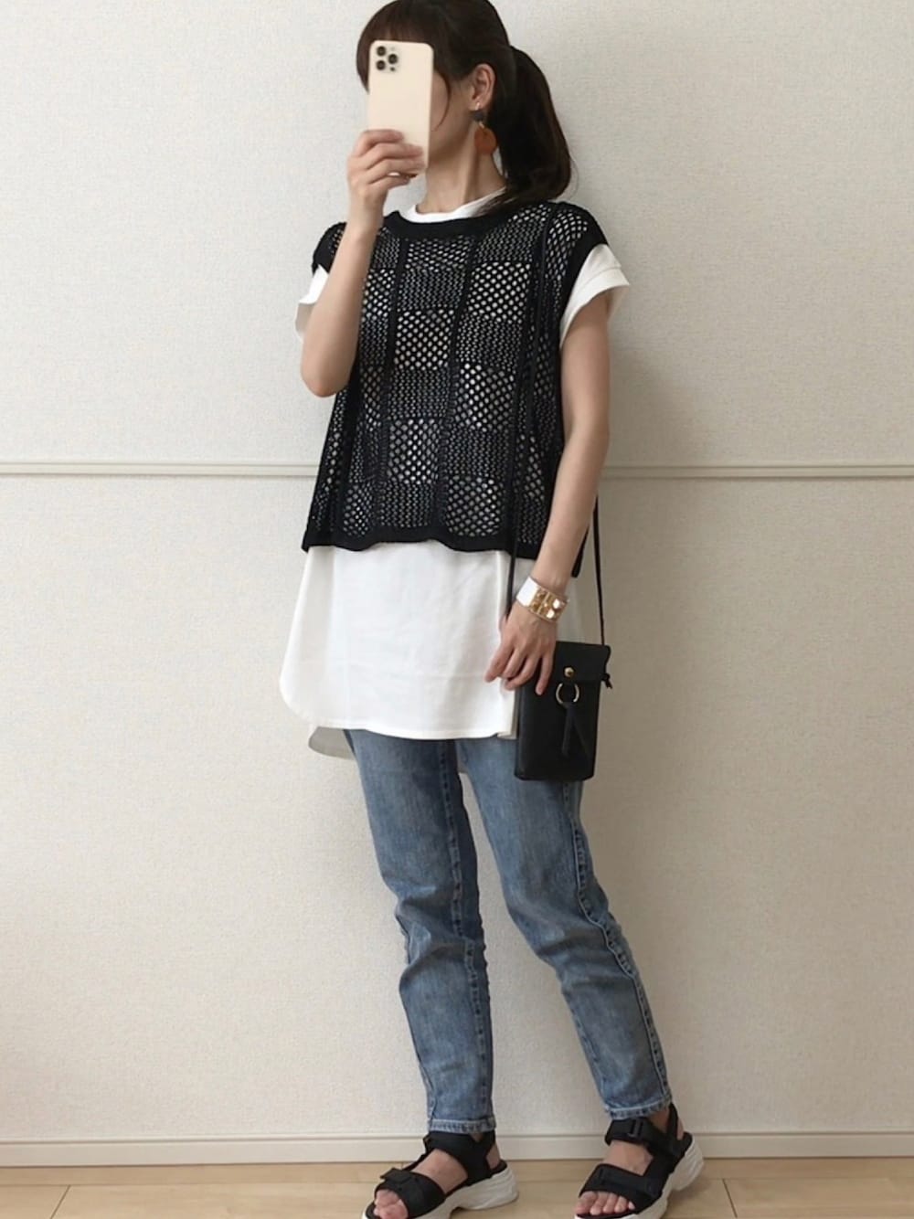 ブラック系のベスト、ホワイト系のTシャツ/カットソー、ブルー系のデニムパンツを着用したレディースの夏コーディネートの1枚目の写真