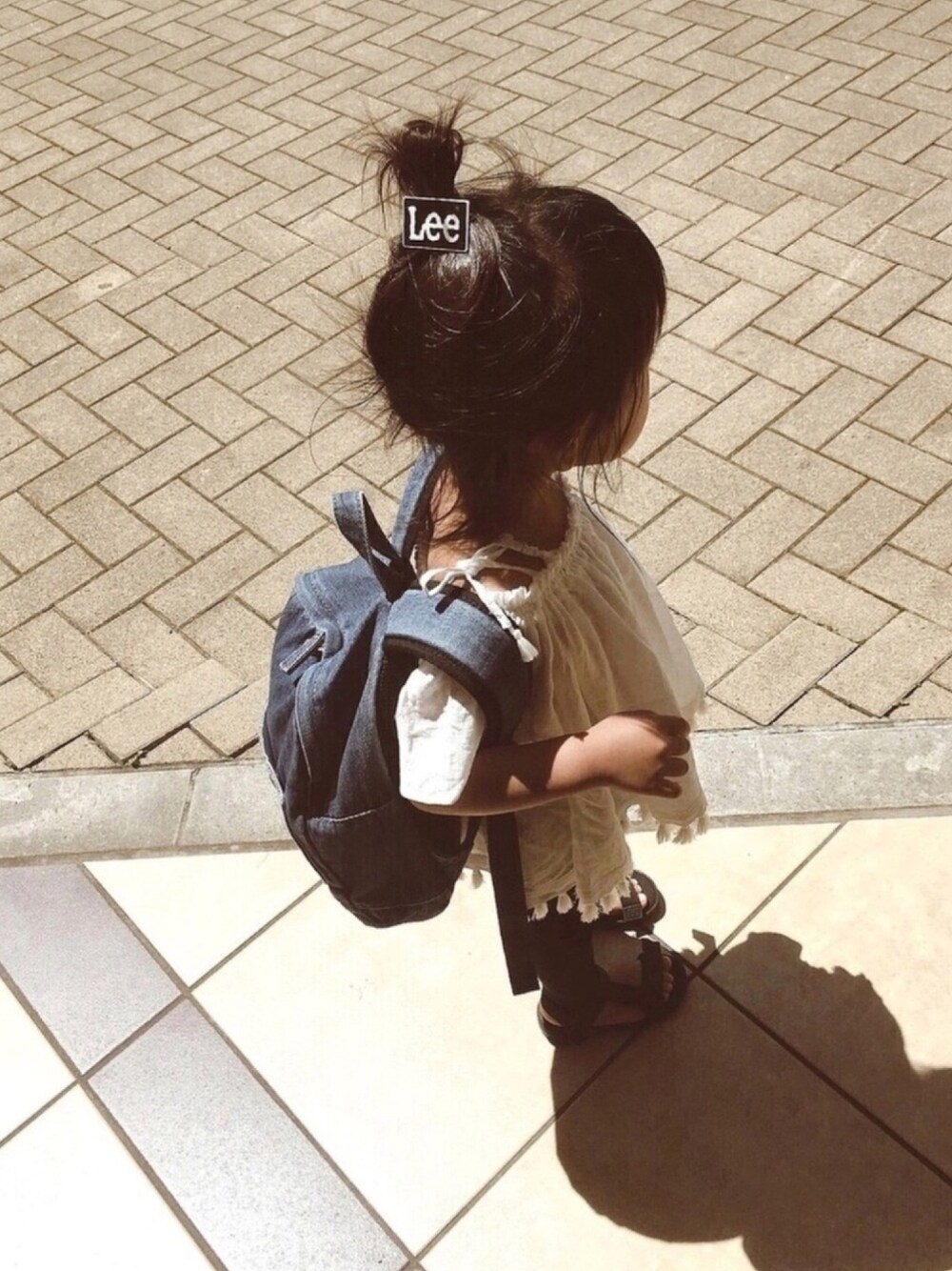 ホワイト系のチュニック、ブラック系のその他パンツ、ブラック系のサンダルを着用したキッズの夏コーディネートの1枚目の写真