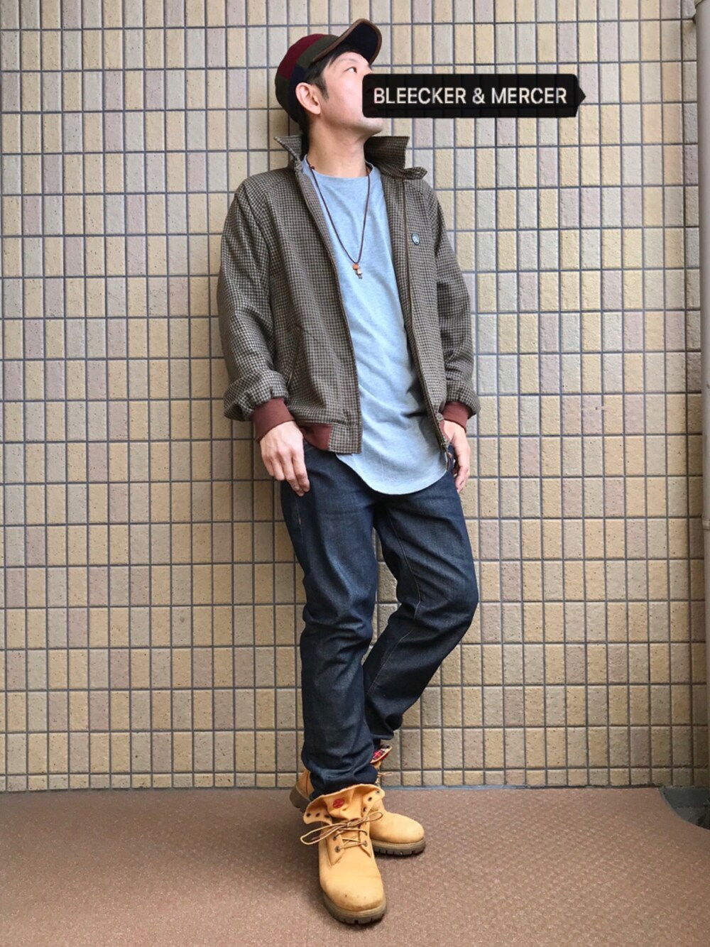 ブラウン系のブルゾン、グレー系のTシャツ/カットソー、ブルー系のデニムパンツを着用したメンズの秋コーディネートの1枚目の写真