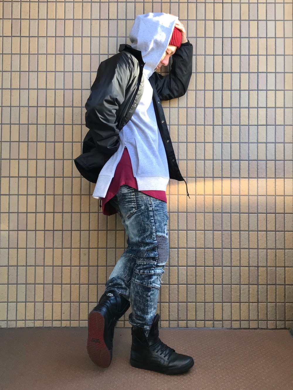 ブラック系のブルゾン、グレー系のパーカー、レッド系のTシャツ/カットソーを着用したメンズの冬コーディネートの1枚目の写真