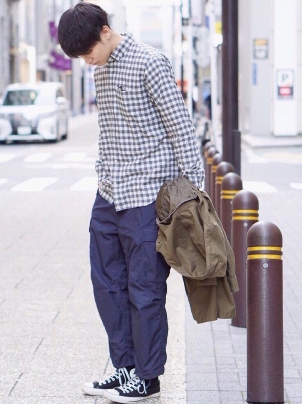 ブラック系のスニーカー、ブルー系のその他パンツ、グリーン系のモッズコートを着用したメンズの春コーディネートの1枚目の写真