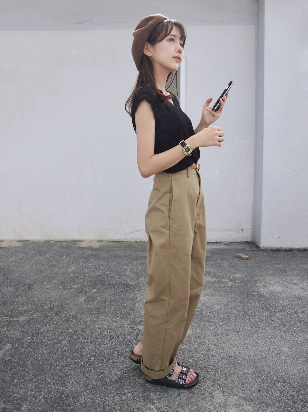 ブラック系のニット/セーター、ベージュ系のチノパンツ、ブラック系のサンダルを着用したレディースの夏コーディネートの1枚目の写真