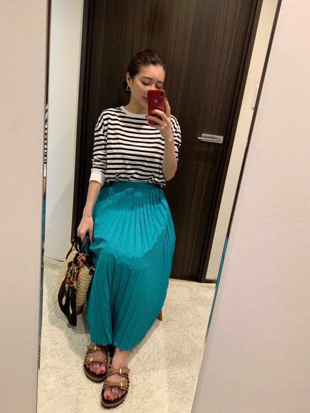 ブラック系のTシャツ/カットソー、グリーン系のスカート、ベージュ系のかごバッグを着用したレディースの春コーディネートの1枚目の写真