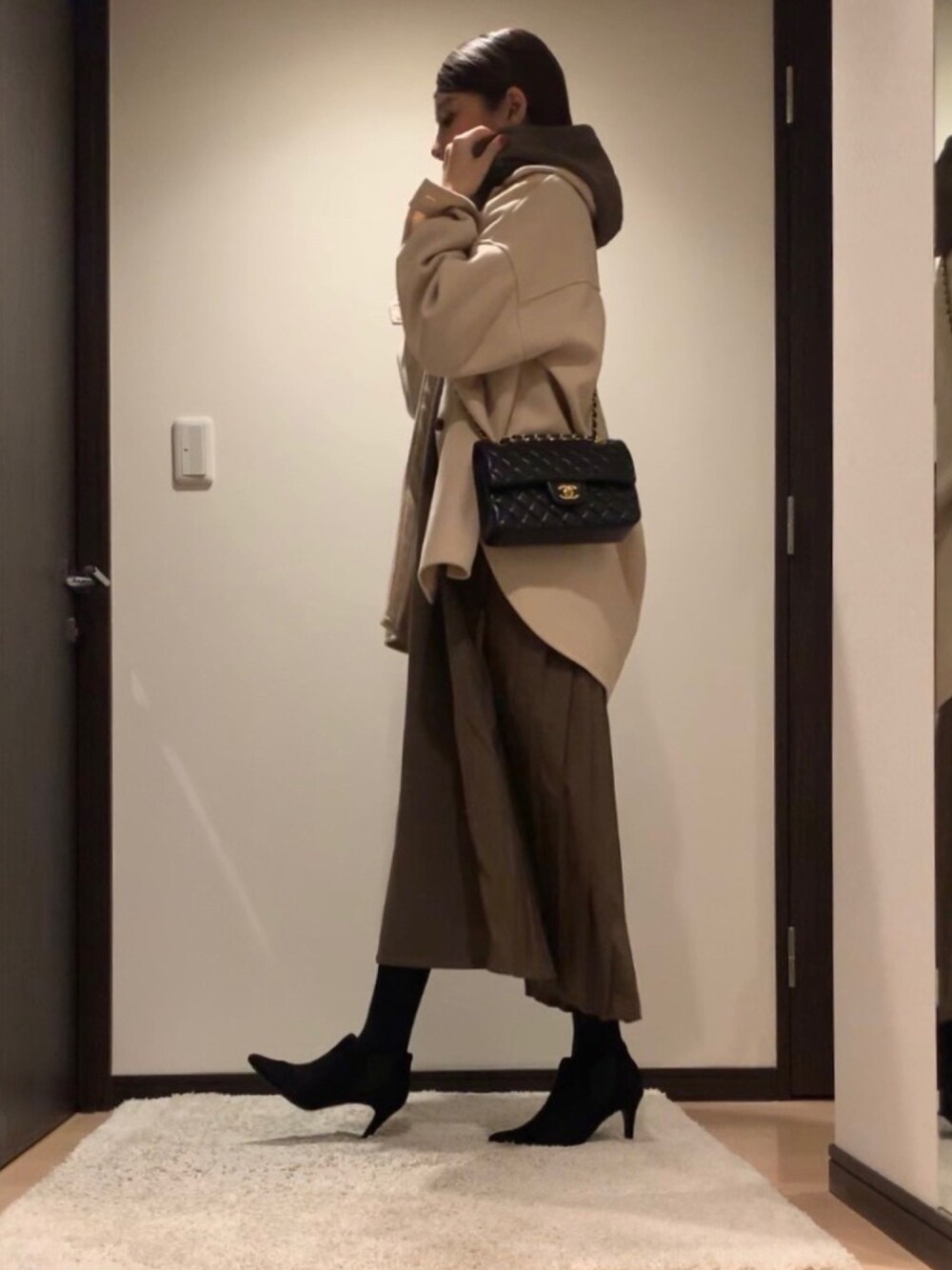 ベージュ系のカバーオール、ブラウン系のワンピース、ブラック系のブーツを着用したレディースの秋コーディネートの1枚目の写真