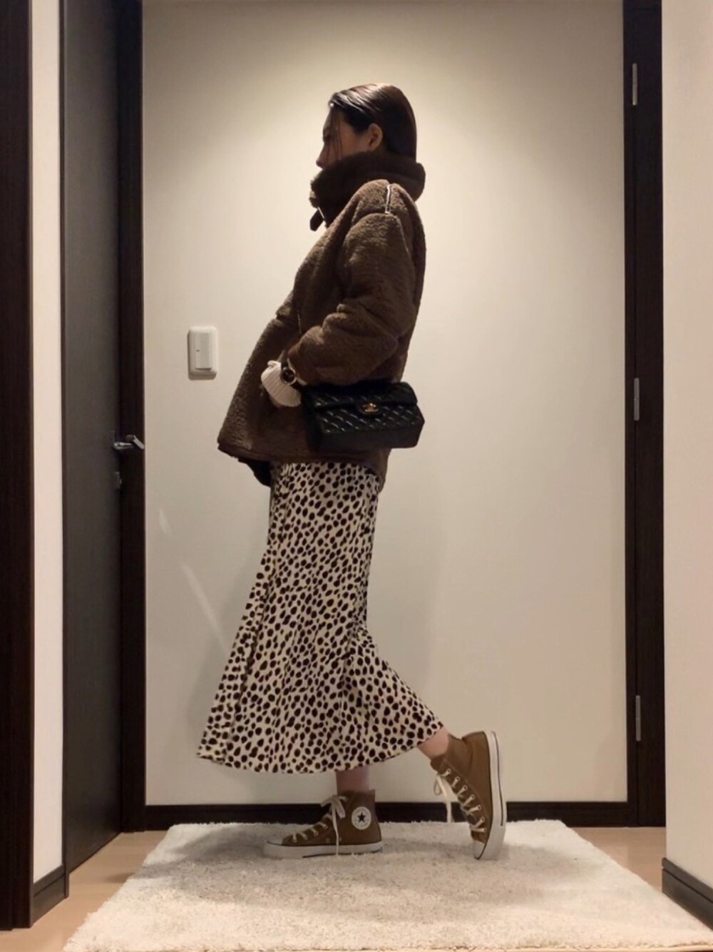 ブラウン系のブルゾン、ホワイト系のスカート、ブラウン系のスニーカーを着用したレディースの冬コーディネートの1枚目の写真