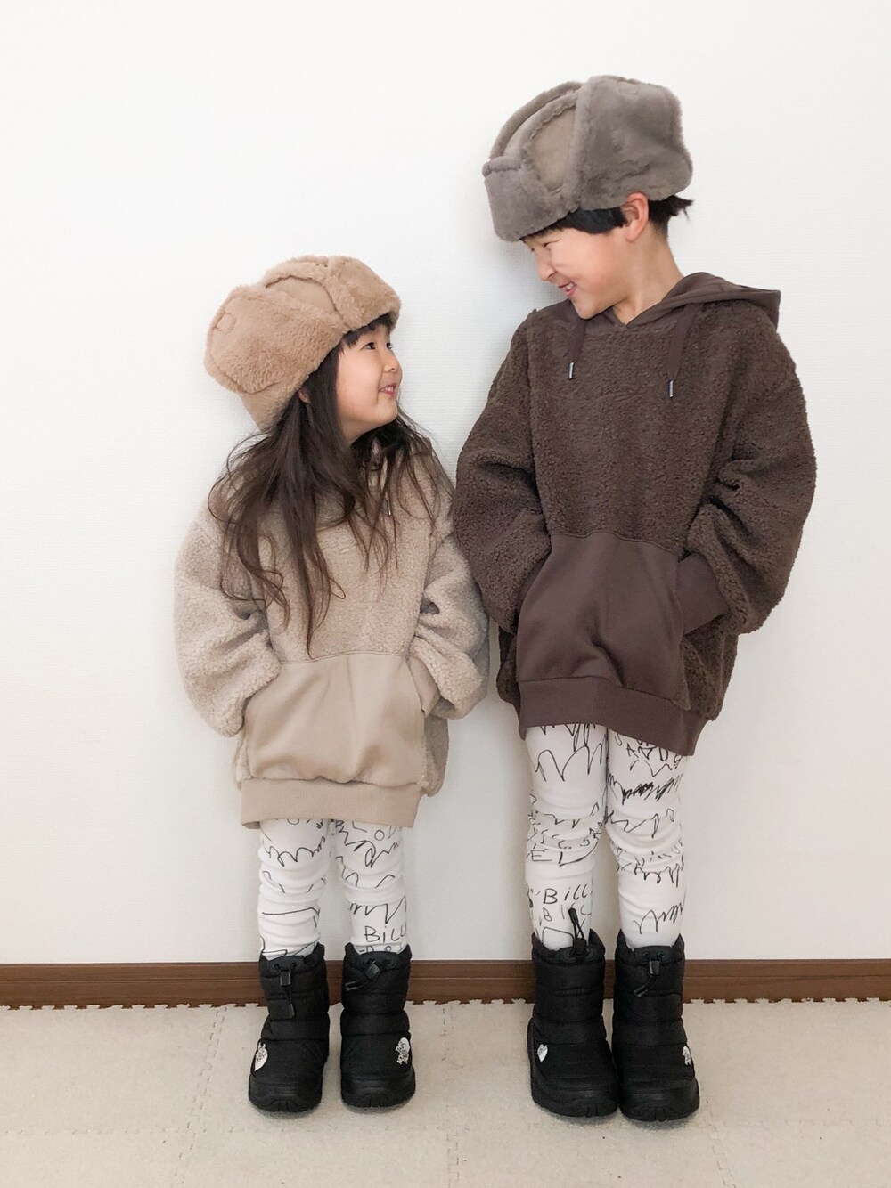 ブラウン系のパーカー、ベージュ系のパーカー、ブラック系のブーツを着用したキッズの春コーディネートの1枚目の写真